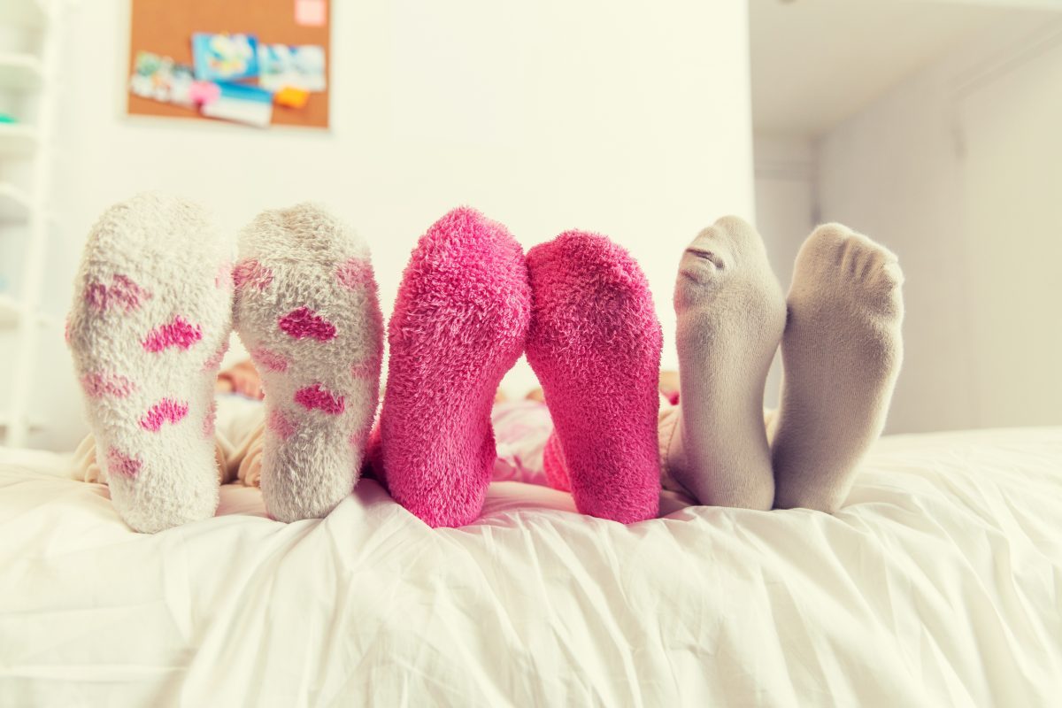 close up of women feet in socks on bed at home P2ATF54
